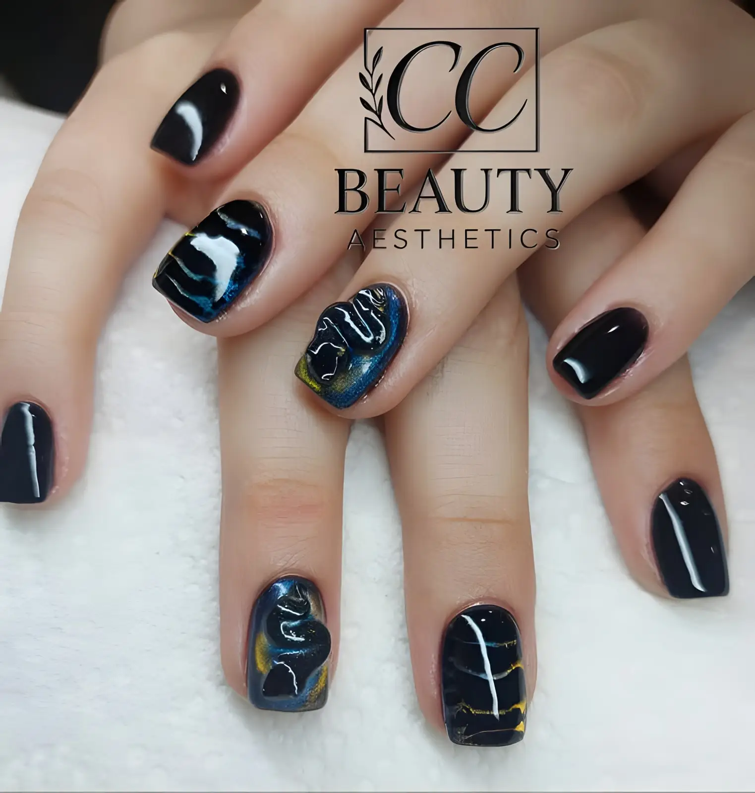 Short black nails, some marbled with blue and gold