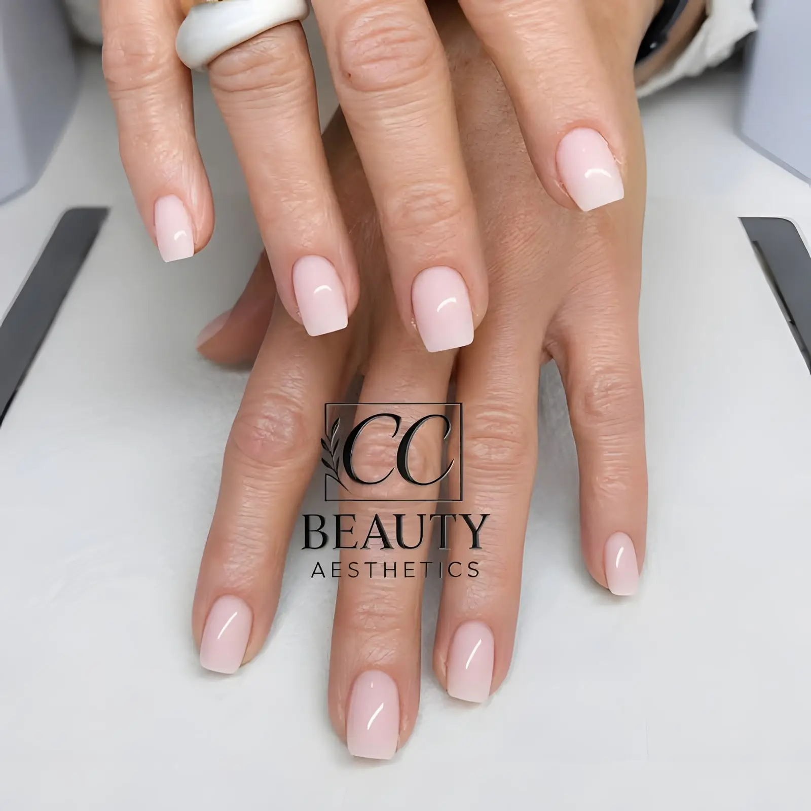 Short square nails in a sheer milky pink